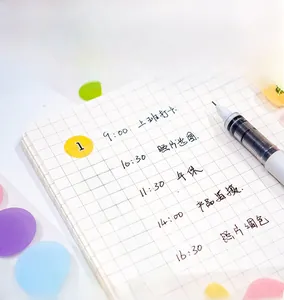 Macro shot of colorful translucent dot stickers with black numbers on a grid notebook