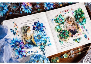 Detail of PET decorative tapes featuring blue-purple flowers and gems on a grid notebook