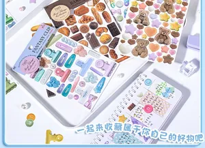 Detail of DIY journal stickers with cute bear and bakery themes on a white tray