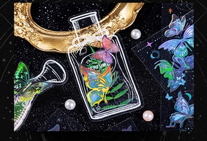 Detail of holographic butterfly and perfume bottle PET stickers on a starry background