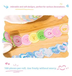 Detailed view of cartoon emoji and blue heart washi tape rolls for DIY planners