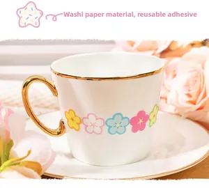 Macro detail of floral washi stickers applied on a white ceramic mug with gold rim