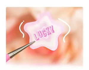 Detail of star-shaped lucky sticker with pink gradient and tweezers display