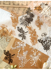 Makro-Detail von Vintage-Spitzenpapier-Aufklebern mit hohlen Blumen- und Schmetterlingsmotiven