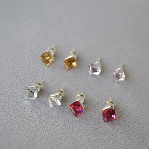 Detail view of square cut crystal earrings in amber, lilac, clear, and pink sets