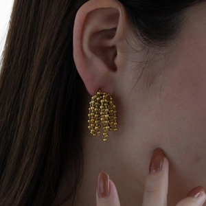 Elegant gold beaded chain fringe flower earrings shown on model for a trendy look