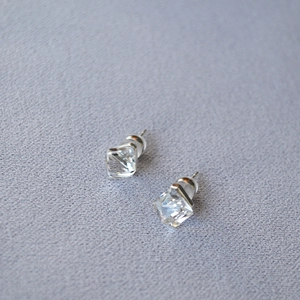 Detail view of square cut clear rhinestone stud earring with silver prong setting