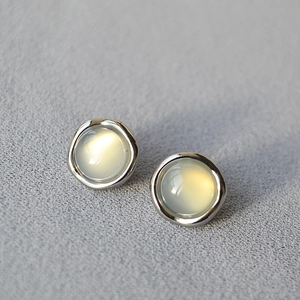 Irregular round silver studs with inlaid lapis lazuli on a minimalist gray background