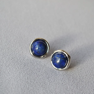 Macro shot of minimalist lapis lazuli earrings set in polished 925 silver studs