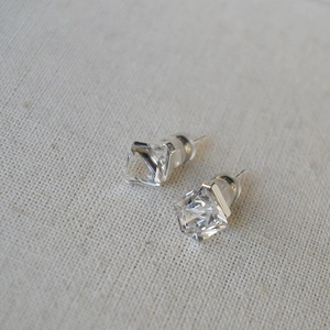 Detailed view of square-cut clear crystal stud earrings with silver metal backing