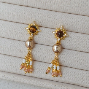 Orecchini vintage placcati oro con occhio di tigre, perle e nappine di perline