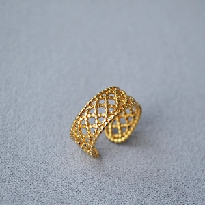 Macro detail of 18K gold adjustable open ring featuring intricate hollow lace mesh texture