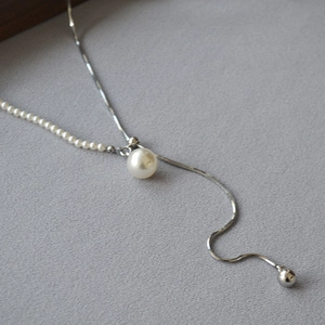 Detail of adjustable Y-shaped pearl necklace featuring silver snake chain and large pearl drop