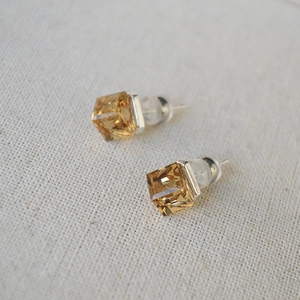 Macro shot of amber square crystal earrings with silver posts and silicone backings