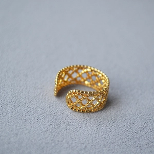 Close-up of golden adjustable ring featuring a sophisticated hollow lace mesh pattern