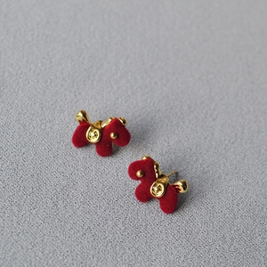 Close-up of red flocked animal studs with gold plating on a stone background