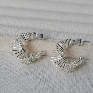 Gros plan de boucles d'oreilles C en argent avec un design en fil spirale multicouche