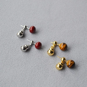 Detail of silver gourd stud earrings with red beads and golden tiger eye stones
