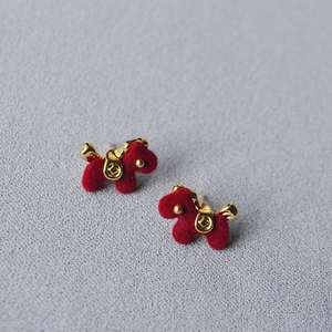Macro detail of red flocked puppy studs with gold saddle and coin texture