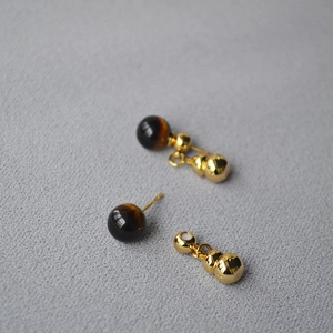 Detail showing tiger eye stone studs with detachable gold hulu pendant accessories