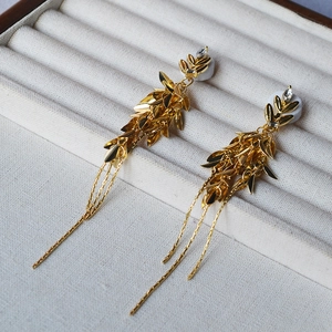 Gros plan de boucles d'oreilles épi de blé doré avec de longs glands sur un coffret