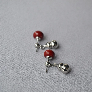 Close-up of red tiger eye gourd drop earrings with textured 925 silver finish