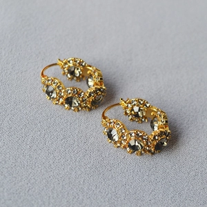 Macro detail of vintage brass gold earrings with smoky crystals and small diamonds