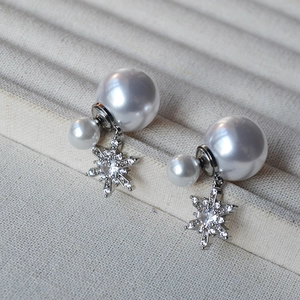 Detail of snowflake tassel earrings featuring double pearls and shimmering zircon stones