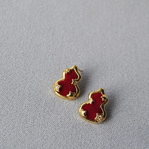 Vue détaillée des boucles d'oreilles gourde en velours rouge avec bordure dorée et zircons