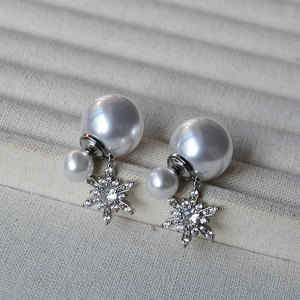 Macro view of double pearl earrings featuring a rhinestone snowflake fringe detail