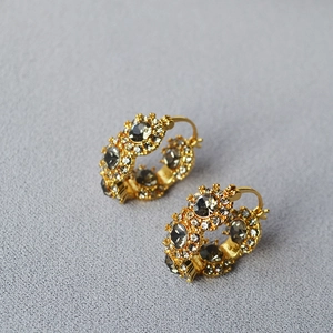 Macro shot of gold-plated vintage earrings with grey crystals and micro-pavé diamonds