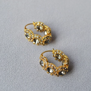 Detail shot of vintage gold-plated hoop earrings with grey crystals and rhinestones