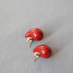 Elegant red enamel teardrop stud earrings with 925 silver needles on gray textured fabric