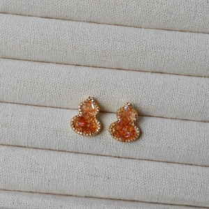 Detail of crystal gourd stud earrings with orange gradient stones and pave diamonds