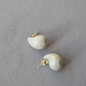 Detail of water drop earrings with cream marble texture and gold plated studs
