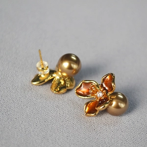 Detailed close-up of retro amber flower earrings with champagne pearl and gold finish