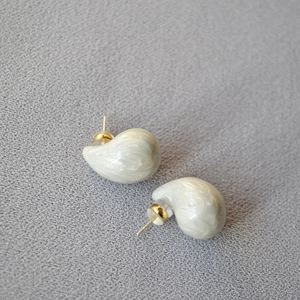 Detail shot of marble-textured resin teardrop earrings with silver pins and secure backs