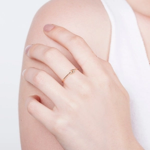 Minimalist handmade gold knot ring shown on model finger for a modern aesthetic look