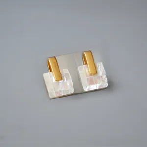 Detail of square mosaic shell earrings with gold matte finish and checkerboard pattern