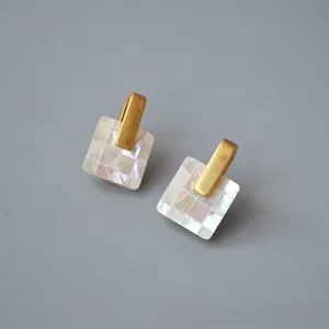Macro detail of square vintage stud earrings with colorful shell mosaic and gold metal