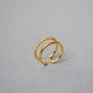 Macro view of gold-plated double-layer ring with sparkling cubic zirconia inlay