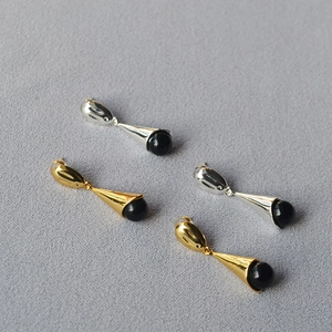Detailed view of long waterdrop earrings in gold and silver with black agate beads