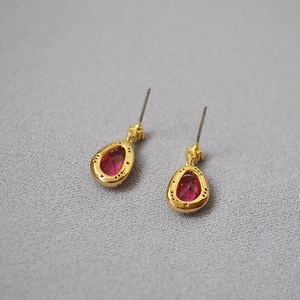 Elegant gold-plated brass stud earrings featuring red pear-cut faceted crystal stones