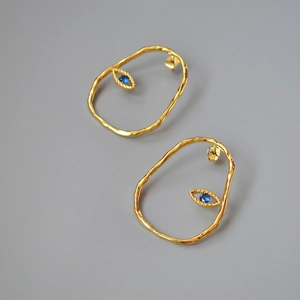 Minimalist gold-plated irregular eye earrings with vintage blue stones and textured metal finish