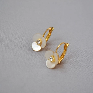 Detail of clover earrings with white shell petals and a sparkling center crystal