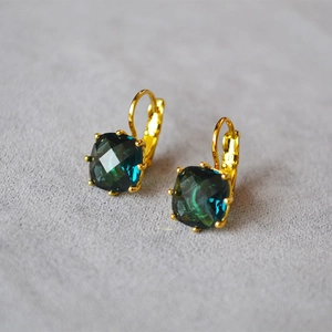 Détail de boucles d'oreilles en pierre bleu foncé avec fermoir à levier doré