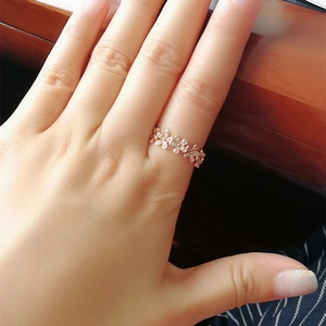 Bague marguerite élégante en or rose avec zircons micro-pavés sur un doigt de femme