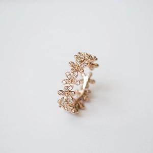 Détail d'une bague marguerite en or rose avec 110 zircons sertis pour un style floral chic