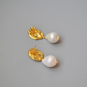 Vintage gold textured leaf earrings with baroque freshwater pearls in a flat lay view