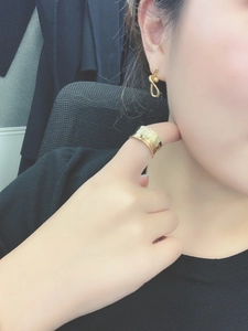 Detailed view of hammered gold adjustable ring and twisted hoop earrings on a model